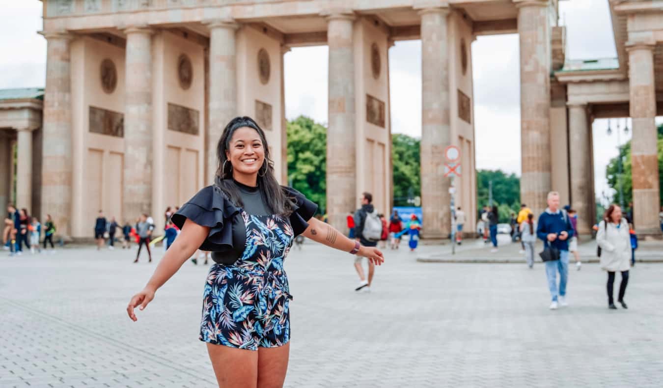 Avid traveler Ava posing near Brandenburg Gate in Berlin, Germany