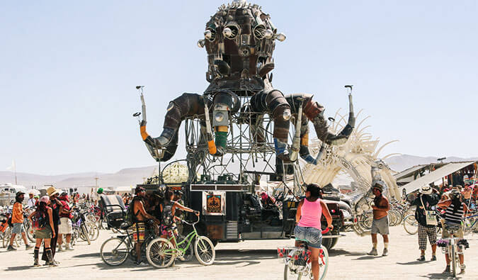 people on bikes around a giant sculpture at Burning Man Festival