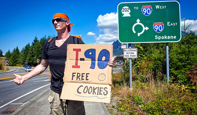 Matthew Karsten hitchhiking in the USA holding a sign offering free cookies