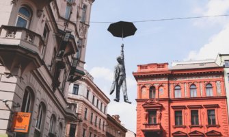 Statue of a man hanging from a telephone line from an umbrella in Prague, Czech Republic