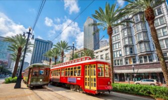 A bright red streetcar driving around sunny New Orleans, USA
